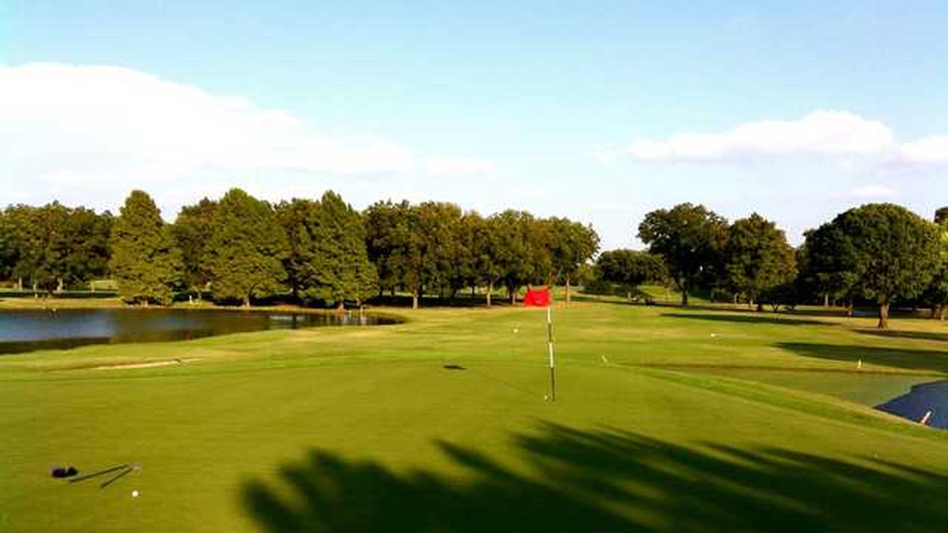Red flag on a green beside a pond at Jimmy Clay Golf Course in Austin.
