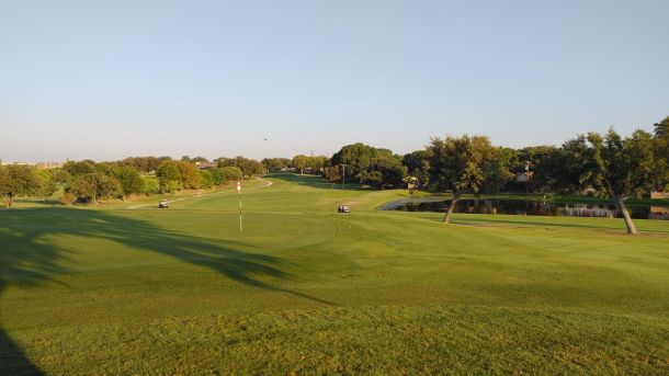 Fairway and golf carts among mature trees at Northern Hills Golf Course in San Antonio.