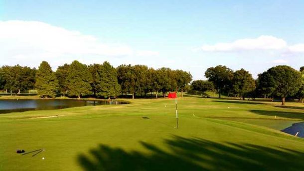Red flag on a green beside a pond at Jimmy Clay Golf Course in Austin.