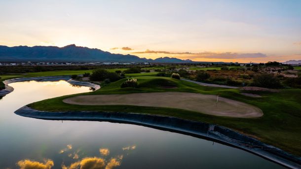Sunset over a pond and green at the Painted Dunes golf facility in El Paso.
