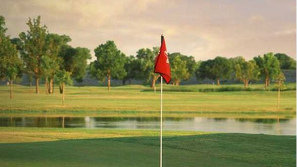 Red flag on a green beside water at Lake Park Executive Golf Course in Lewisville.